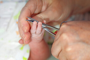 woman hand using thin metal scissors trim child nails on a small hand, showcasing care and attention to grooming