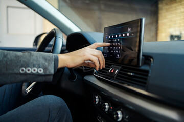 Cropped picture of a businessman's hand typing directions on display on GPS in his car.