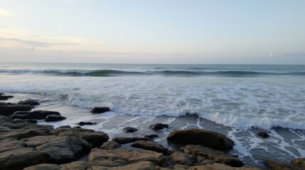 Obraz premium Tranquil Ocean Waves Gently Lapping on Rocky Shoreline at Dusk