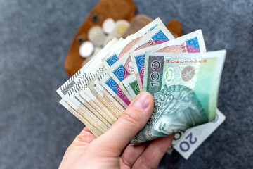 Hand Holding Polish Zloty Banknotes with Wallet
