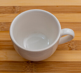 empty white cup for tea or coffee on brown wooden striped background. caffe of kitchen drink concept