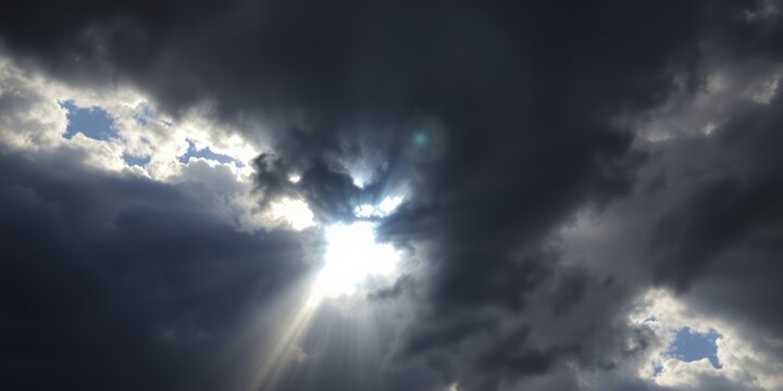 Rays of light break through dark clouds, symbolizing hope and divine presence, especially relevant during Easter and other Christian observances