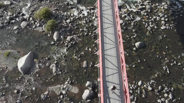 Drone footage of a girl running on a  bridge in San Fabian de Alico, Veguillas Bridge