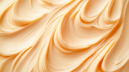 Obraz premium Creamy peanut butter forms a beautiful pattern, resembling soft waves of light orange against a white canvas.