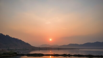 Serene Sunset Over Calm Waters with Hills in the Background