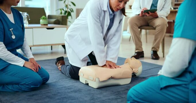 First aid, training and doctor with cpr on dummy for cardiac arrest, emergency healthcare and life saving lesson. Medical simulation, people and learning chest compression for heart attack survival