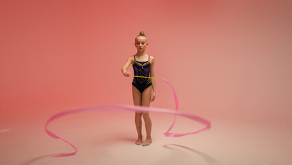 Caucasian little girl kid daughter schoolgirl female gymnast schoolgirl child dancer ballerina athlete perform gymnastics exercise twirling spinning gymnastic tape dance ballet studio pink background