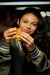 Customer savoring a hamburger in a fast food restaurant