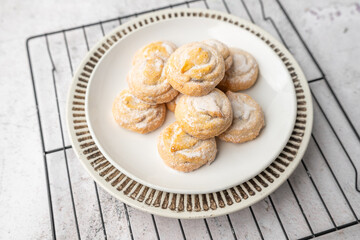 Italian cherry sugar cookies on a white plate. Powder sugar covered cookies.