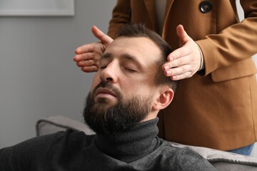 Psychologist working with patient during hypnosis session indoors, closeup