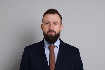 Handsome bearded man in suit on grey background