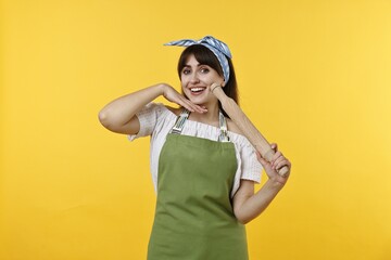 Happy woman with rolling pin on yellow background
