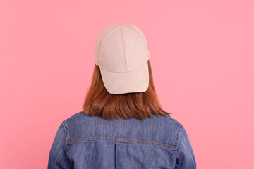 Woman in stylish baseball cap on pink background, back view. Mockup for design