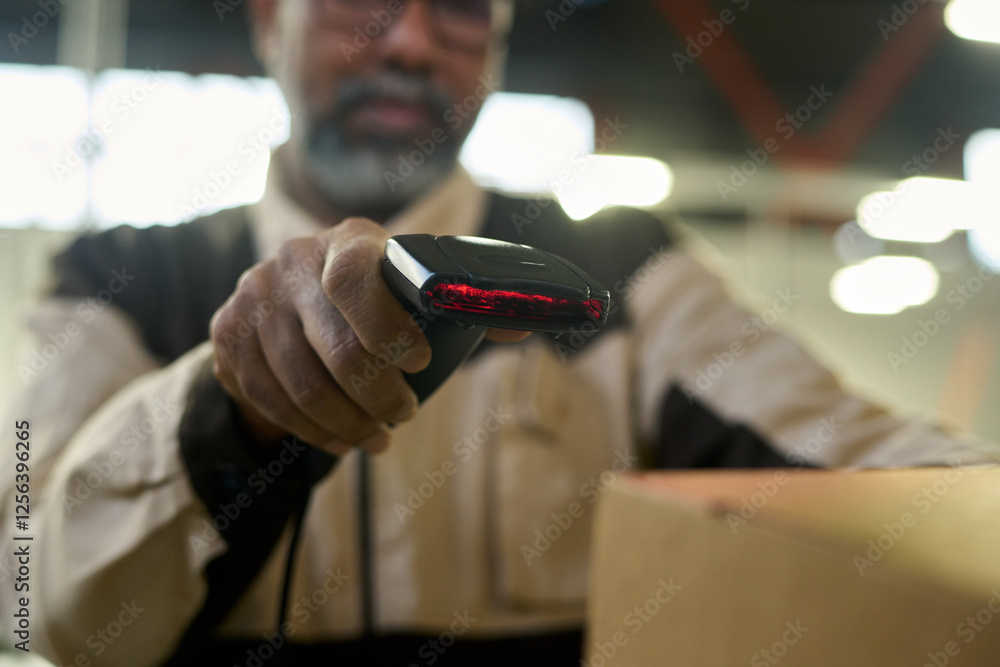 Fototapete focus on hand of warehouse manager scanning barcodes on packed cardboard boxes while checking inform