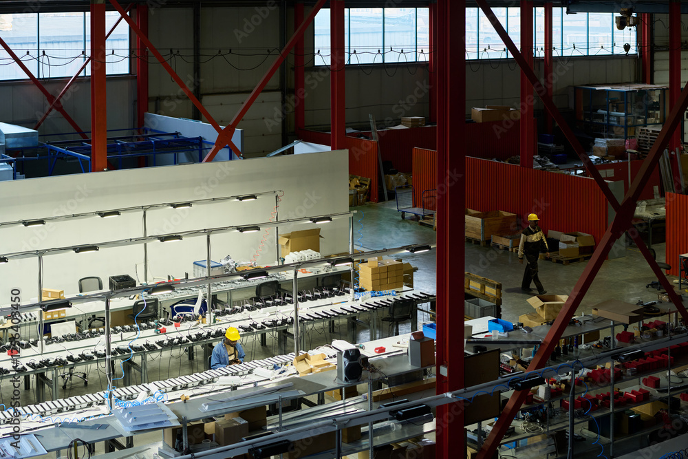 Poster high angle of spacious workshop of modern factory with two engineers and workplaces for producing in
