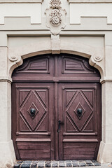 Ornate wooden door with diamond details and stone framing. Classic architectural detail