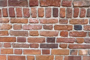 Obraz premium Rustic Aged Brick Wall with Weathered Texture and Varied Red, Brown, and Earthy Tones Ideal for Backgrounds and Architectural Design