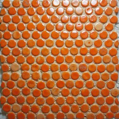 Orange round glazed mosaic tiles with cement grout. Penny circles tile. Tiled wall texture. Geometric seamless pattern of orange round tiles. Construction material, home repair, kitchen backsplash
