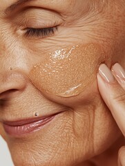 Fototapeta premium Close-Up of a Mature Woman Applying Skincare Cream for Hydration and Anti-Aging Beauty Routine