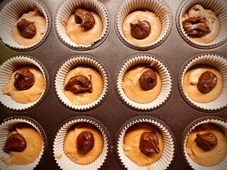 Gorgeous Unbaked Muffins with Chocolate Filling in a Baking Tray ready to be made