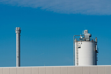 Industrial structures against a vibrant blue sky