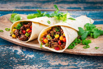 Mexican style burritos - tortilla wrap with spicy minced meat, vegetables and leek served as...
