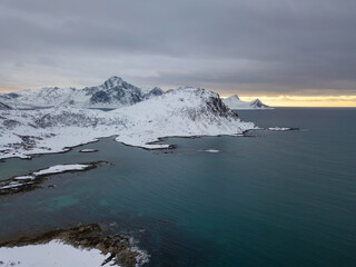 Aerial drone panoramic view of amazing Lofoten Islands, Norway. Mountains and sea top view during sunset. Natural landscape at the Winter scenery in scandinavia.