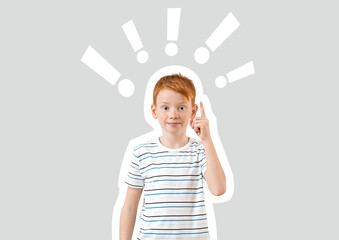 Cute little boy with raised index finger on light background