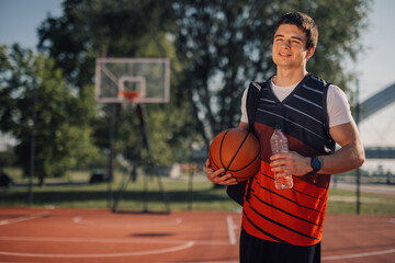 Fototapeta premium Basketball player taking a break on outdoor court