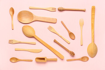 Wooden kitchen utensils on pink background