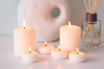 Burning candles on white background