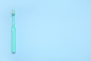 Blue plastic toothbrush on color background.