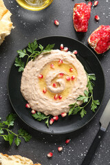 Plate of tasty baba ghanoush on black background