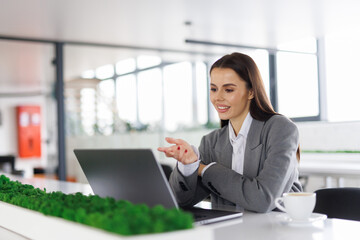 Young smile woman having video call via laptop in the office