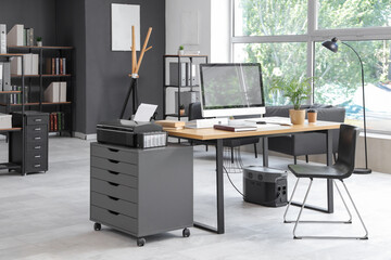Interior of stylish office with workplace, modern computer and chair