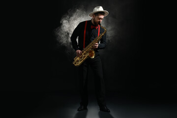 Professional musician playing saxophone on black background with smoke