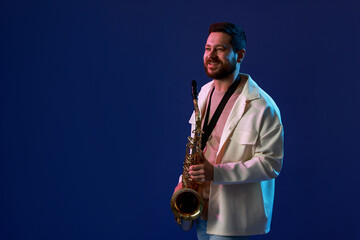 Professional musician with saxophone on blue background. Space for text