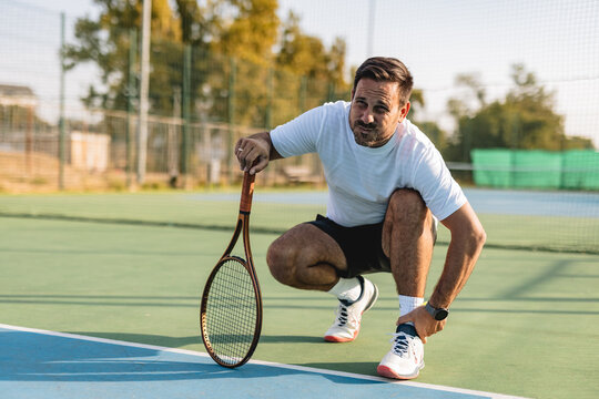 A male tennis player on training with a racket poised for a powerful swing
