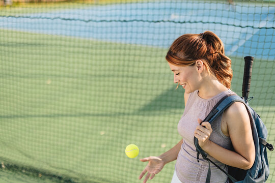 A female tennis player with a racket poised for a powerful swing