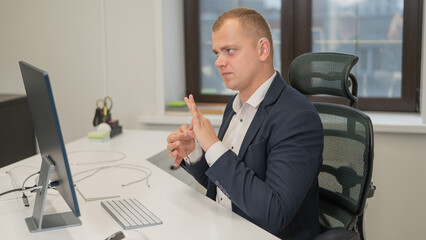 Caucasian deaf man uses sign language for online negotiations.