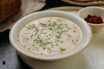 Creamy lentil soup with flatbread, sesame seeds, chili flakes, and lemon, served in an elegant style