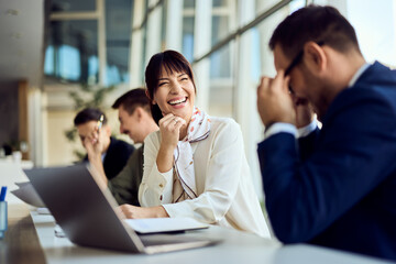 Team Members Sharing a Laugh During a Collaborative Office Meeting