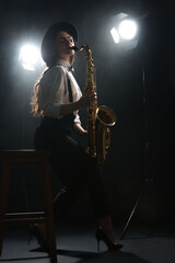 Professional musician playing saxophone on dark background with lights and smoke