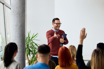 Smiling Male Speaker Engaging with Audience in a Modern Seminar Room