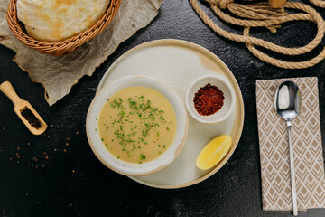 Creamy lentil soup with flatbread, sesame seeds, chili flakes, and lemon, served in an elegant style