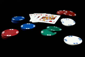 Poker cards and betting casino chips on a black background. Card game gambling.