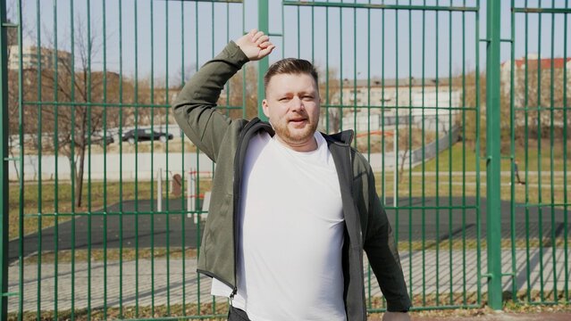 Sportsman warming up before running in city park