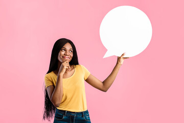 Cheerful Black Lady Holding White Speech Bubble Above Head And Thinking Touching Chin Posing Over Blue Studio Background, Looking Aside. Customer's Thoughts, Comment And Feedback Concept. Mockup