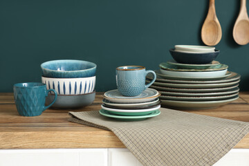Wooden table with different plates near blue wall in kitchen