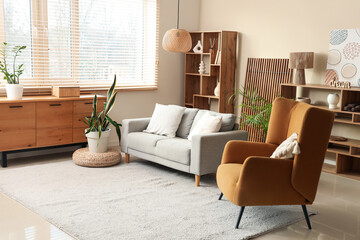 Interior of cozy living room with sofa and brown armchair
